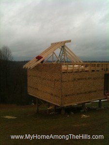 Securing the rafters in place for our small cabin