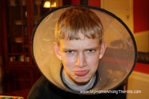 The boy wearing an Elizabethan collar
