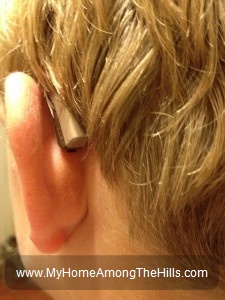 Hearing aid behind his ear